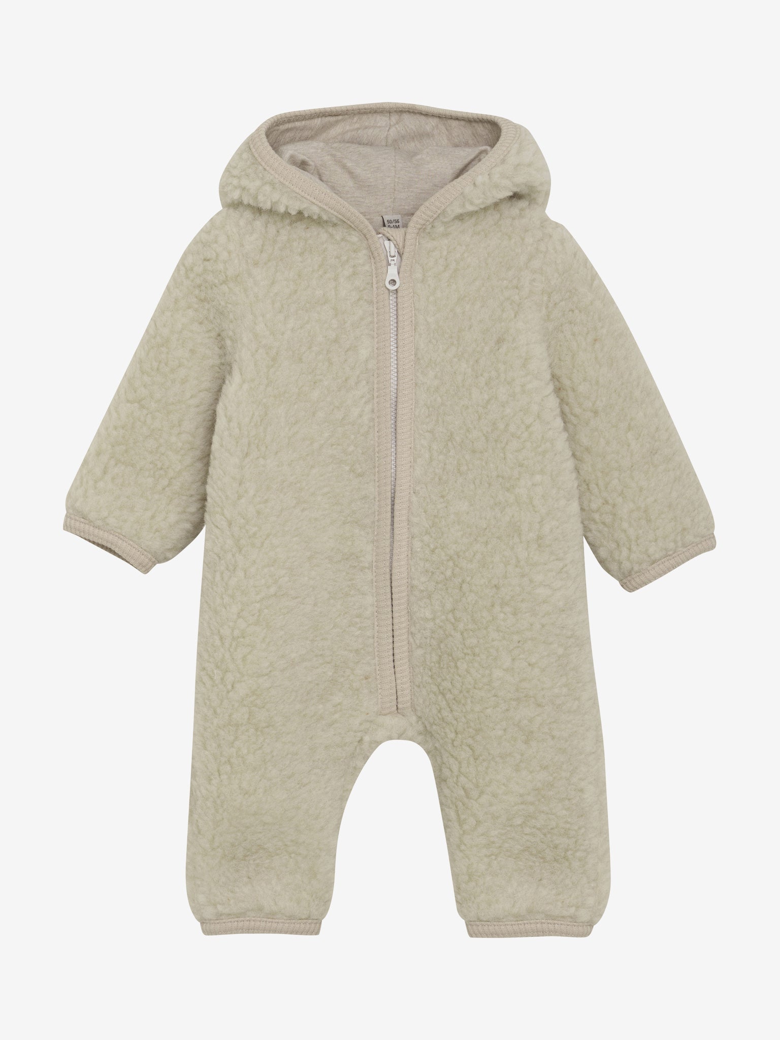 Detailvaade meriinokombiné kangakattest — pehme Teddy-tekstuur ja naturaalne värvitoon